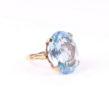 A 9ct gold cocktail ring set with a large oval pale blue stone, approx UK size 'L', 7.2g.