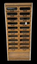 An early to mid 20th century haberdashery shop cabinet consisting of a double bank of twenty glass