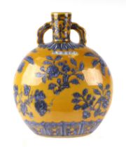A Chinese moon flask decorated with fruit and foliage on a yellow ground, 28cms high.