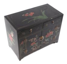 A Chinese lacquer side cabinet with two frieze drawers above a cupboard, decorated with flower on