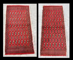 Two small Persian Turkoman woollen hand-made rugs with geometric designs on a red ground, each