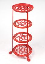 A red painted cast aluminium four-tier pan stand, 70cms high.