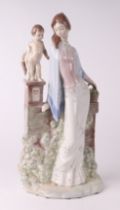A Lladro style figural group depicting a young girl standing beside a cherub, 45cms high.