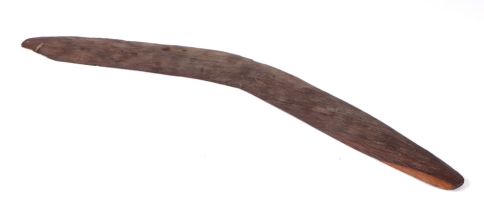 An Australian Aboriginal chip carved boomerang, 60cms wide.