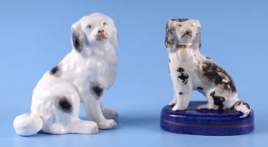 A 19th century Staffordshire figure of a dog, 10cms high; together with another similar on an oval