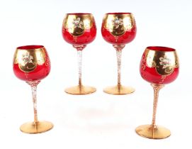 A set of four Murano ruby glass goblets with applied gilt and enamel decoration, one glass with