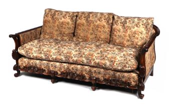 A 1920's Maple & Co. style carved walnut and upholstered 17th century inspired country house sofa