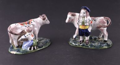 A Delft figural group depicting a cow and milkmaid, 14cms wide; together with another similar (2).