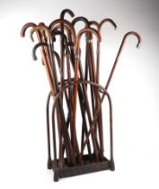 An unusual country house domed brass and iron stick stand of eight divisions, with a selection of