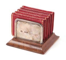 A set of Charles Dickens miniature books on a silver and oak stand, 6.5cms wide. Condition Report