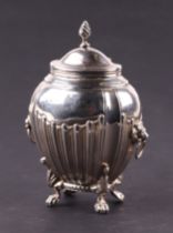 A silver tea caddy on lion paw feet, with hinged flame finial lid and lion mask ring handles, rubbed