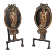 A pair of 19th century iron and brass andirons decorated with panels depicting neo-classical