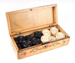 A set of 19th century turned ebony and bone draughts or backgammon counters in a box with painted