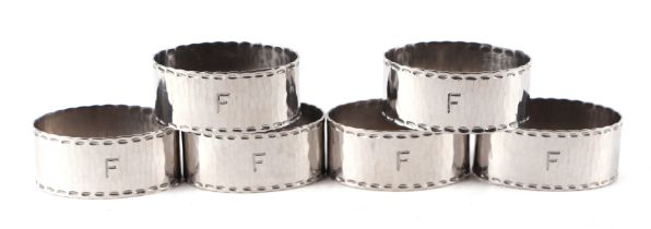 A set of six Keswick School of Industrial Arts hammered Staybrite steel napkin rings, initialled '