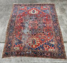 A large Persian Heriz rug with geometric design, on a rust ground, 290 by 356cms.