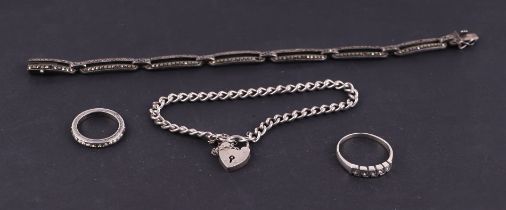 Two silver dress rings; together with a silver padlock bracelet and a silver and marcasite