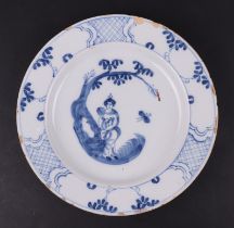 An 18th century Bristol Delft plate decorated with a Chinese woman holding a fan under a tree, 23cms