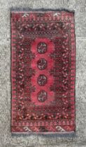 A Persian prayer rug, having repeating guls on a red ground within a multi geometric border, 90cm by