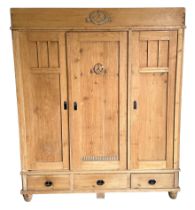 A Continental pine triple wardrobe with three drawers to the base and fitted interior, 164cm wide