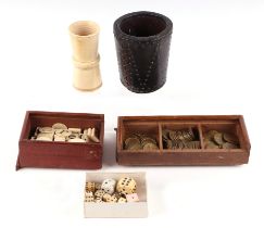 A collection of antique gaming items, including dice, brass gambling tokens, two dice shakers