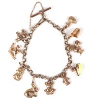 A 9ct gold charm bracelet with various charms to include a cockerel, a rabbit, a teddy bear and a