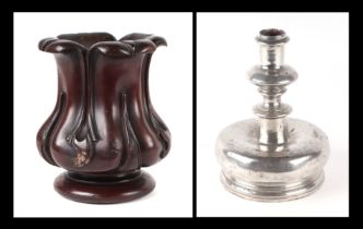 A Victorian carved mahogany vase, 20cms high; together with a squat metal candlestick, 18cms high (