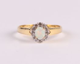 An 18ct gold ring set with a central oval opal surrounded by diamonds, approx UK size 'N', 2.3g.