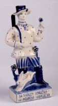 A Russian porcelain blue and white figural candlestick in the form of a hunter carrying his rifle,