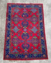 A Turkish rug with repeated medallion design, on a red ground, 183 by 273cms.