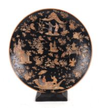 A large Chinese famille noir charger decorated with figures, flowers and butterflies on a black