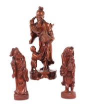 A Chinese hardwood group depicting a fisherman and young boy, 26cms high; together with two