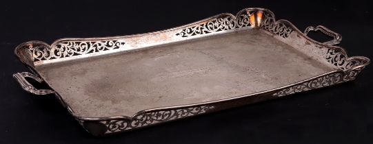 A silver two-handled tray with pierced gallery and engraved with foliate scrolls, having a