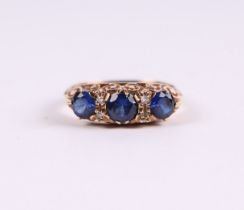 A 9ct gold ring set with three large sapphires interspersed with diamonds, approx UK size 'M'.