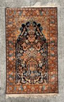 A small silk Kashan rug with central medallion and foliate decoration, on a blue and russet