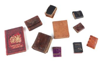 A collection of miniature books including two antique bibles and three copies of Small Rain Under