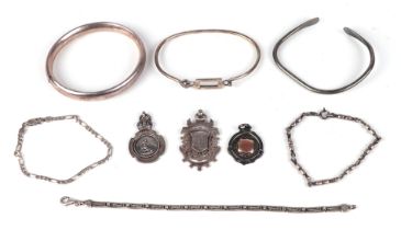 A group of silver bracelets and bangles together with three silver pocket watch fobs, 86g.