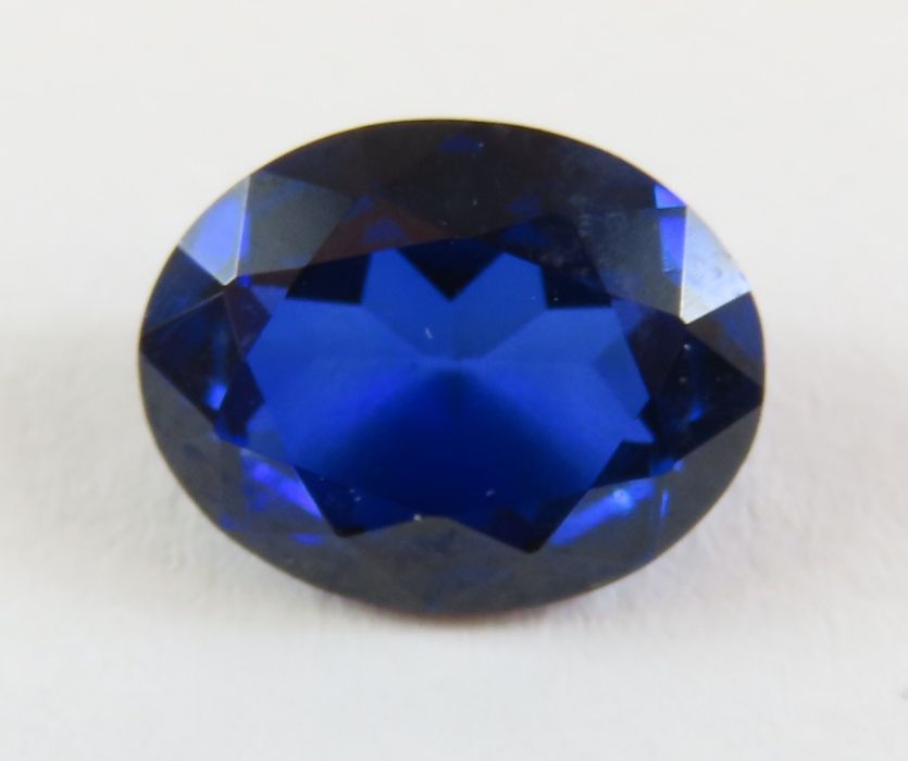 A loose synthetic sapphire, 2.83ct; a collection o