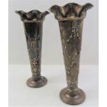 A pair of silver vases with loaded bases, with a f