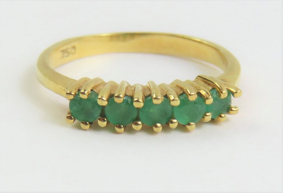 An emerald set band ring, with five round cut ston
