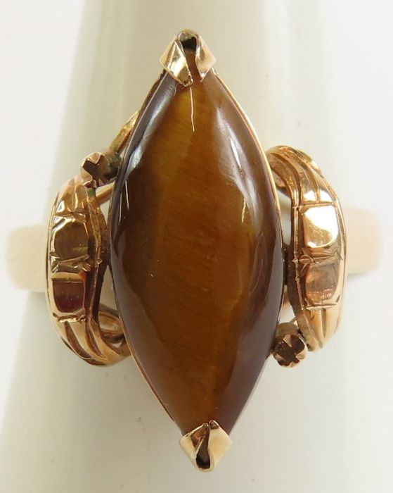 A tiger's eye stone set ring, the single cabochon