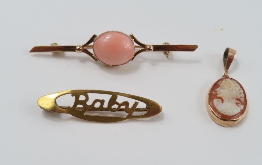 A coral bar brooch; a baby brooch; and a shell cam