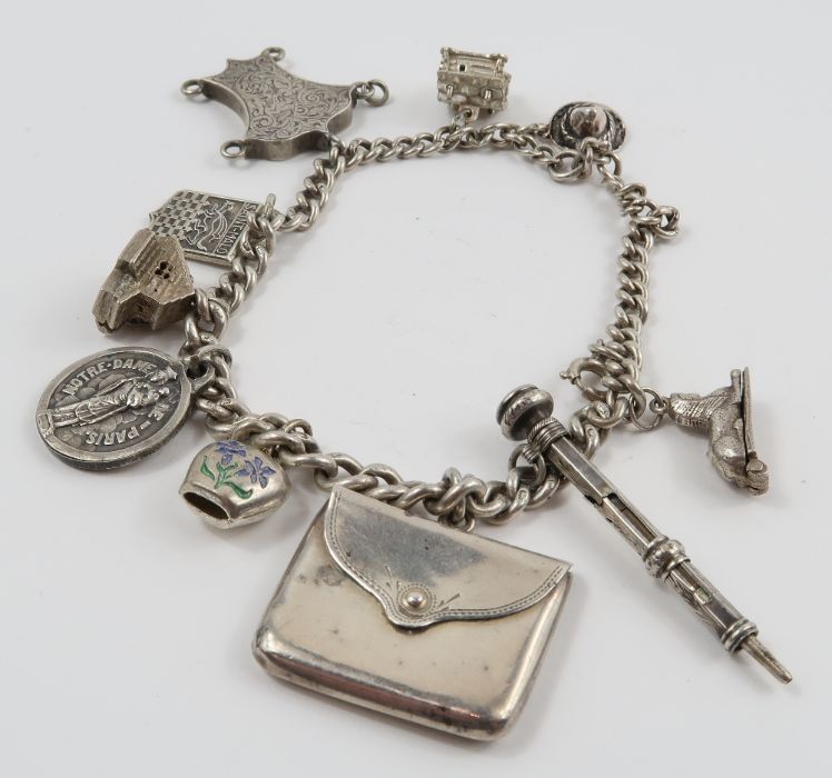 A silver curb link bracelet, with various charms a