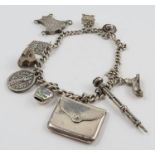 A silver curb link bracelet, with various charms a