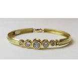 An oval bangle set with five graduated cubic zirco