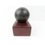 A canon ball on wooden stand