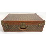 A vintage Louis Vuitton hard-shell suitcase with s