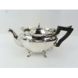 A silver bachelor's tea pot, standing on four feet