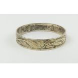 An unmarked patterned silver band ring, finger s