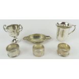 A small silver trophy cup, two silver napkin rings