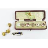 A cased set of five grey mother of pearl buttons,